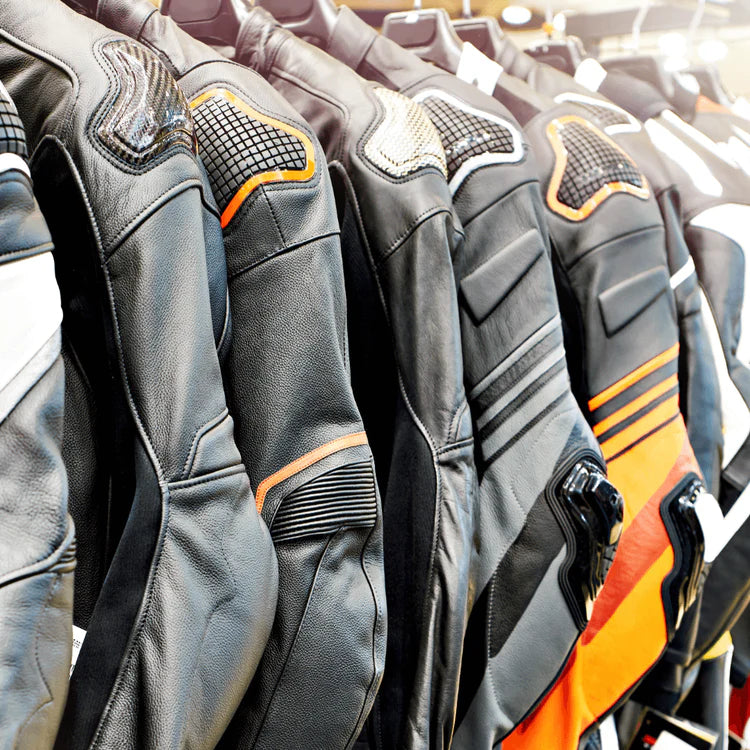 Row of black and orange motorcycle jackets on a rack