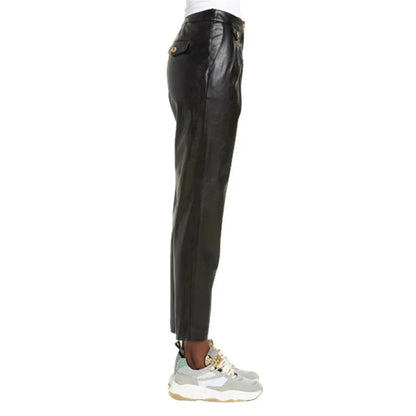 Black leather pants worn with white sneakers on a white background